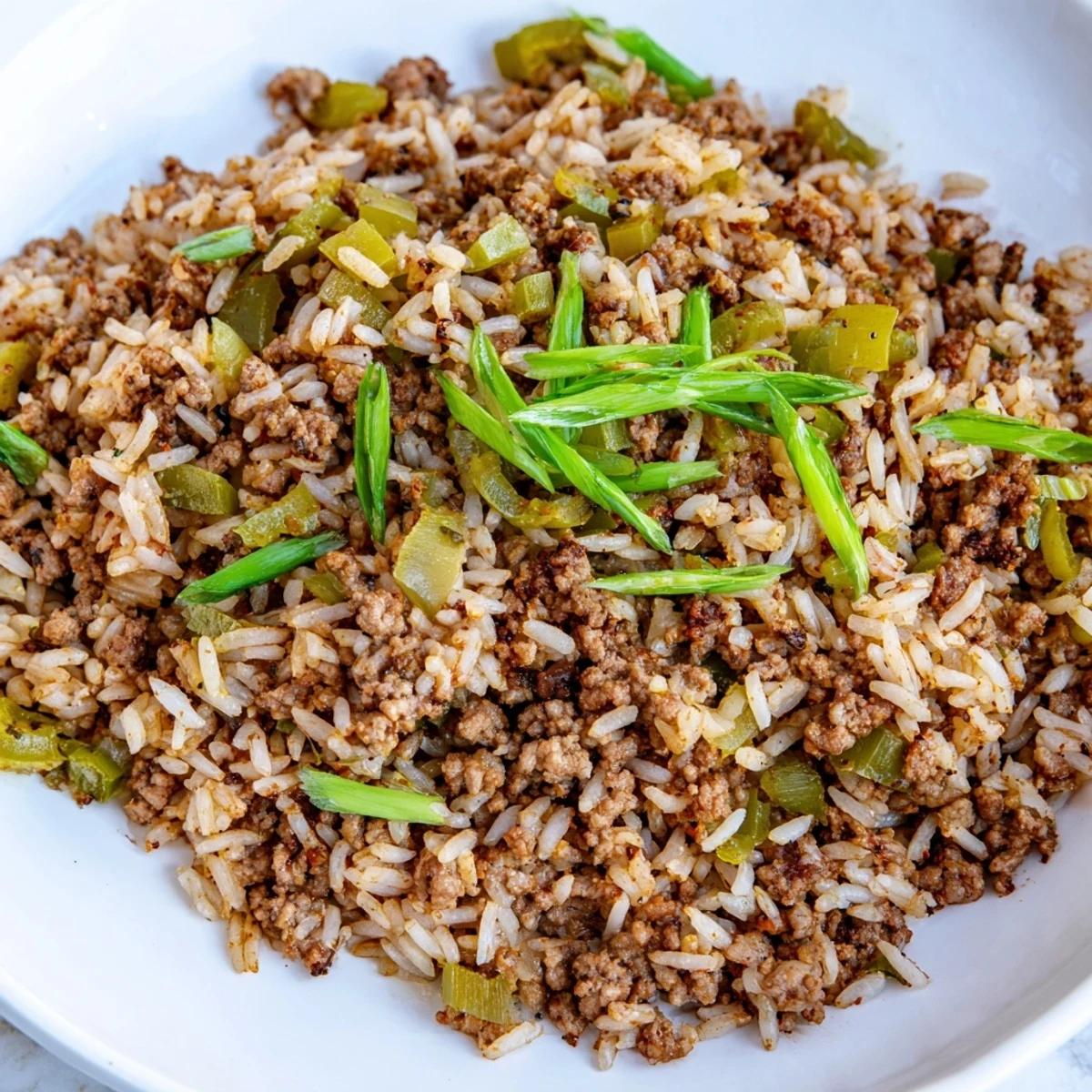 Golden-brown Cajun Dirty Rice, garnished with green onions, ready to be served and enjoyed.