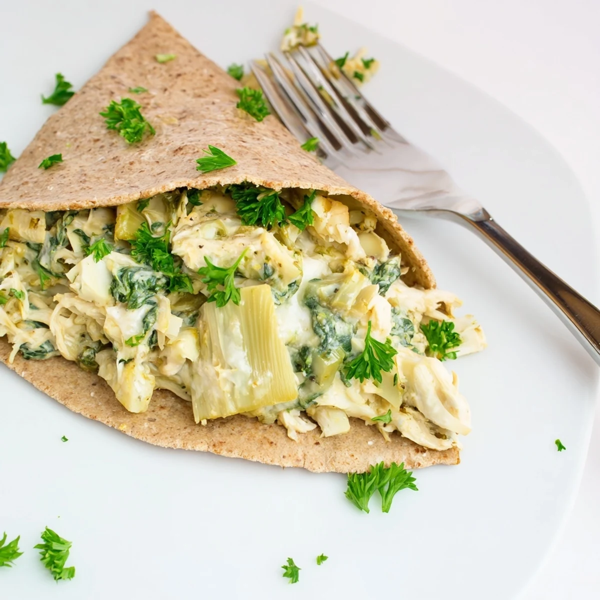 The Spinach Artichoke Chicken Stuffed Pita with golden melted cheese and fresh parsley garnish.  