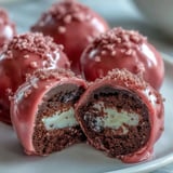 Served chilled from the refrigerator, these Oreo Truffle Balls feature a smooth pink coating decorated with festive sprinkles.