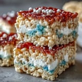 Chewy, colorful Rice Krispies bars in patriotic red, white, and blue, ideal for Independence Day gatherings.