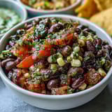 Vibrant three-ingredient cowboy caviar featuring black beans, sweet corn, and fresh pico de gallo in a white bowl.  