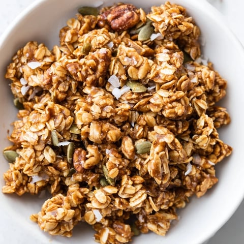 Homemade Granola Clusters with golden oats, crunchy nuts, and sticky honey, perfect for breakfast bowls or snacking.