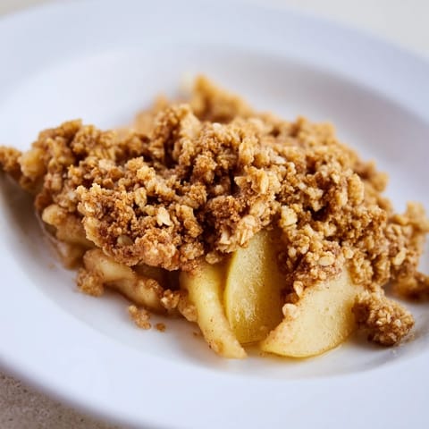 Warm apple and cinnamon crumble, bubbling and golden, baked with a sweet, buttery crumble topping.