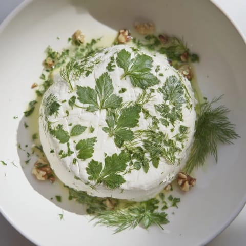 Imagine the soft cheese of The Fossil Record appetizer, intricately impressed with herbs, alongside shelled nuts.