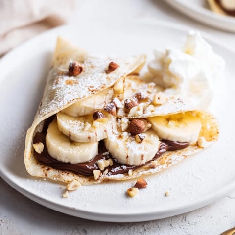 Warm, melted Nutella oozing from a crispy Banana Nutella Wrap, delicious dessert idea.