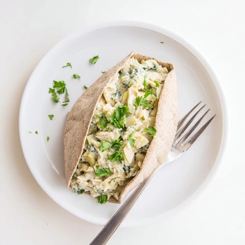 Spinach Artichoke Chicken Stuffed Pita baked until hot, served with lemon wedges on a rustic board.  