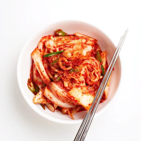 Homemade Korean kimchi with fermented cabbage, carrots, and scallions, ready to serve with rice or soup.