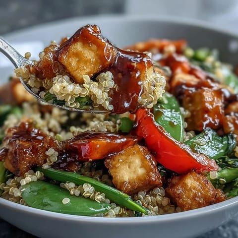 A wholesome vegan bowl filled with golden fried tofu, broccoli, and carrots, drizzled with sweet and savory Asian-inspired sauce.
