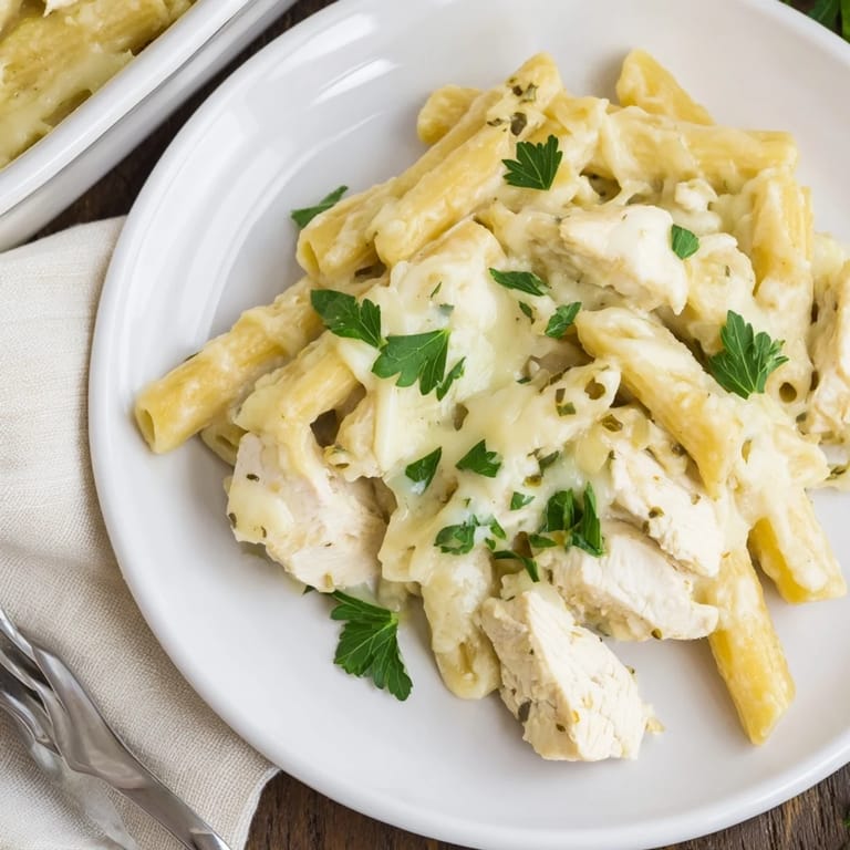 Steaming Chicken Alfredo Casserole fresh from the oven, garnished with fresh parsley.