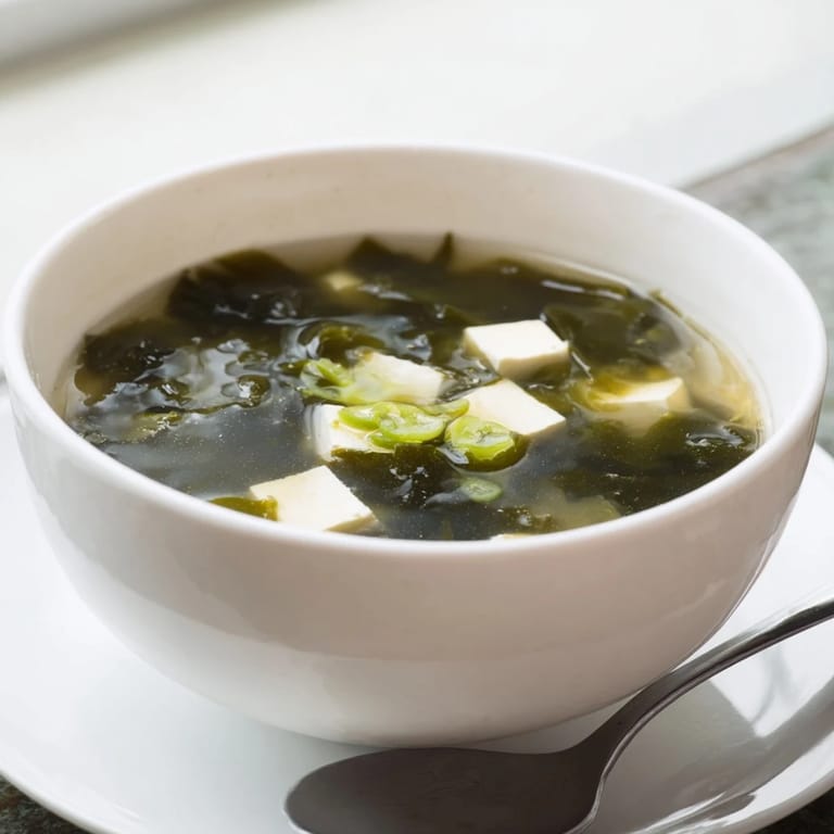 A comforting bowl of Japanese Wakame Soup, with silken tofu cubes and rehydrated seaweed in miso broth.