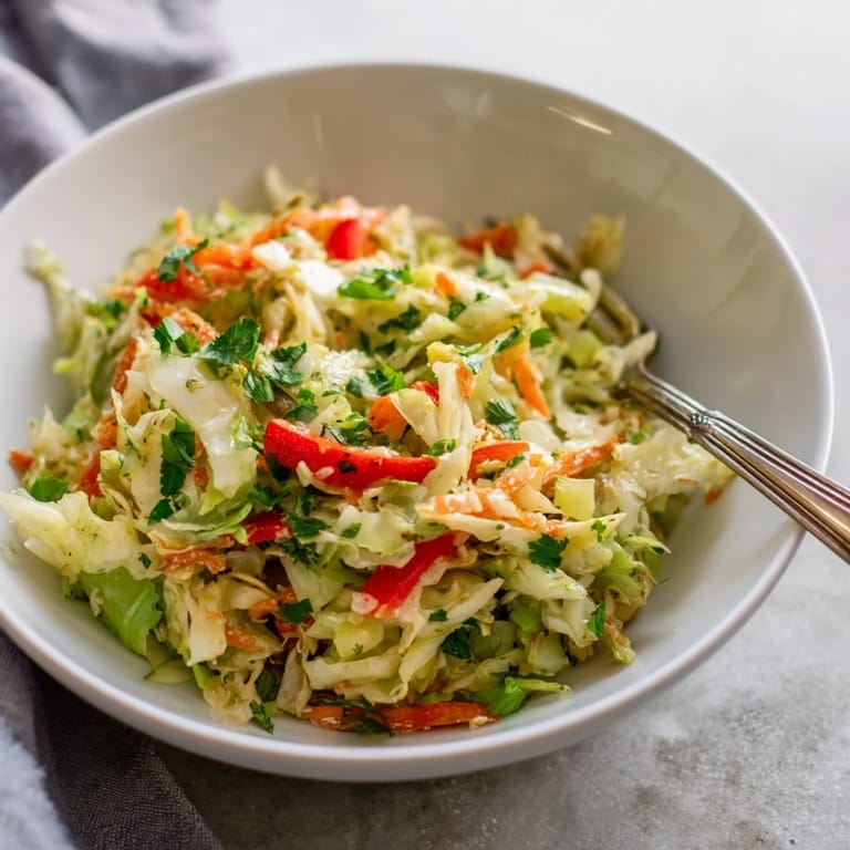 Fork-tender Sauerkraut Slaw tossed in a light apple cider vinaigrette, perfect for pairing with grilled sausages.