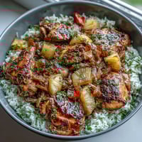 A colorful pineapple chicken and rice skillet with bell peppers, showcasing juicy chicken and vibrant vegetables in a sweet-savory sauce.